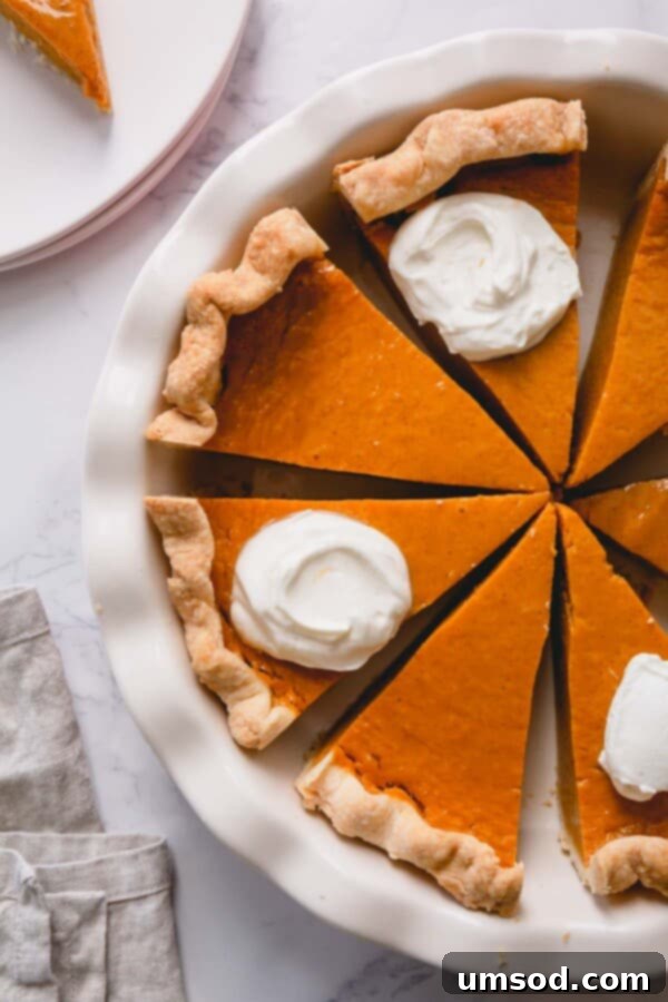 Overhead shot of sliced pumpkin pie in a pie dish.