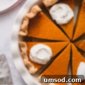 Overhead shot of sliced pumpkin pie in a pie dish.