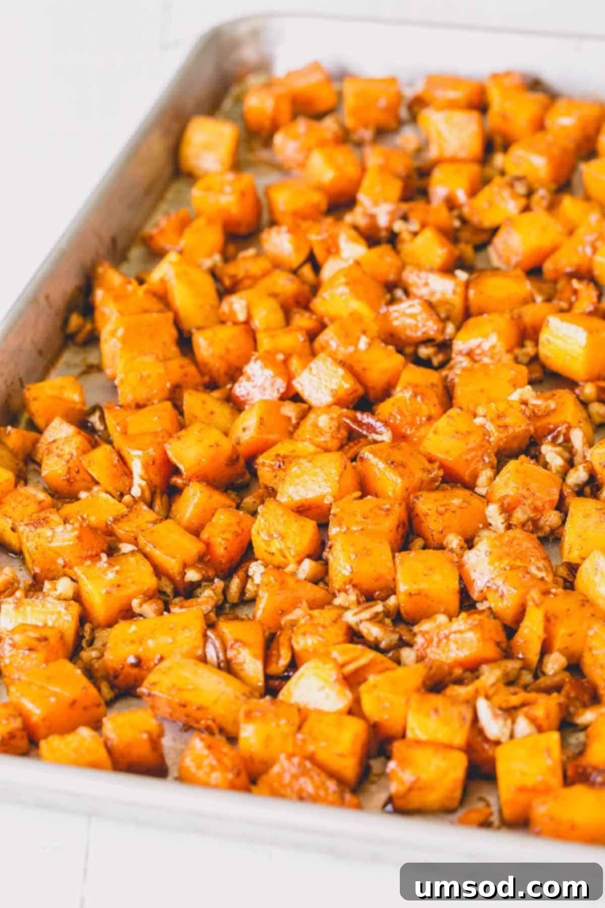 Caramelized Golden Butternut 8 A baking sheet laden with golden-brown roasted butternut squash cubes and toasted nuts, perfectly caramelized and ready to serve.