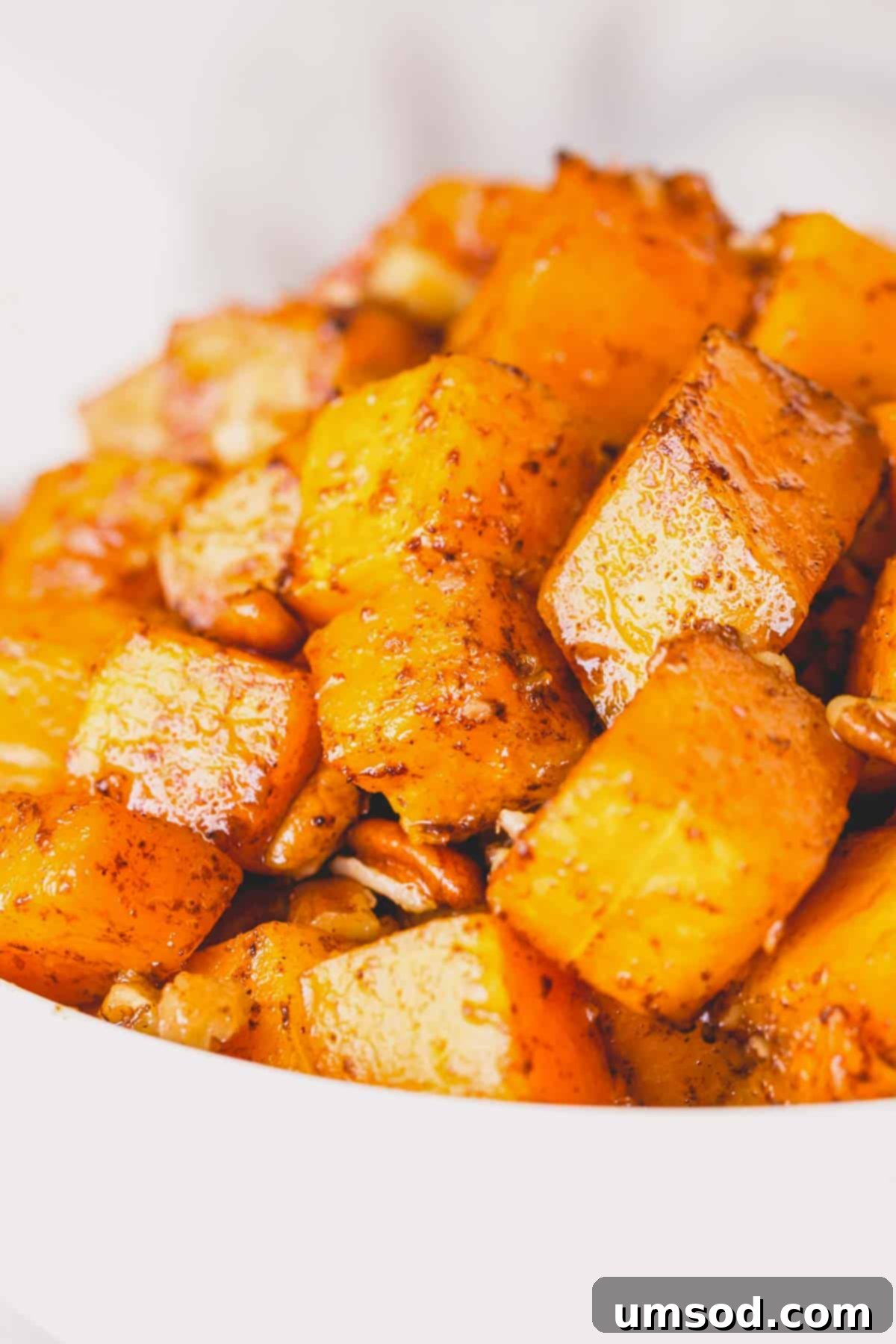 Caramelized Golden Butternut 9 Close-up of a rustic bowl filled with golden, roasted butternut squash cubes and pecans, ready to be served.