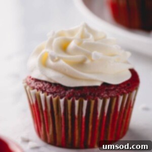 Red velvet cupcake with white cream cheese frosting, captured from a top-down angle.