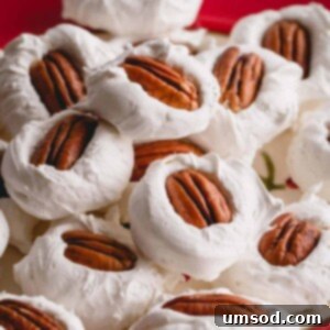 A pile of divinity with pecan halves on top on a red plate.