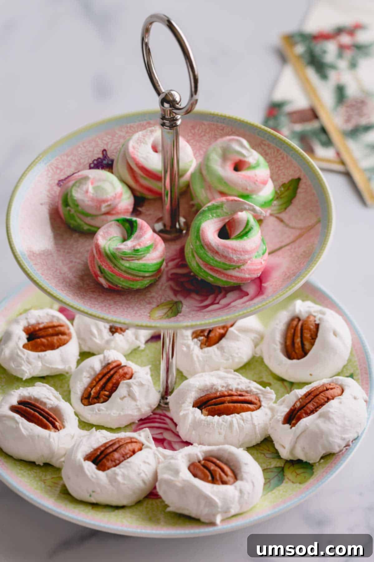 A two-tiered serving platter showcasing a variety of divinity candies, with vibrant colored divinity on the top tier and traditional pecan divinity elegantly arranged on the bottom tier.