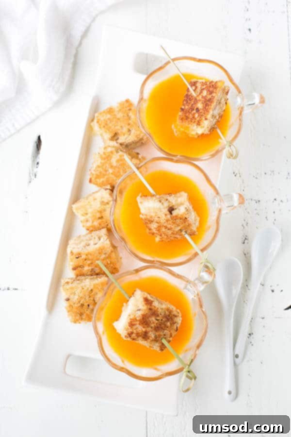 Close-up of a rich, golden butternut squash soup in a bowl, highlighting its velvety smooth texture.