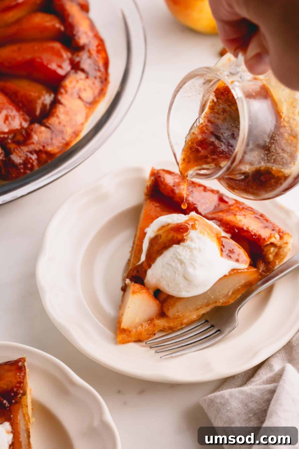 Golden Caramel Pear Tart 13 Pear syrup being poured over a slice of French pear pie topped with vanilla ice cream, creating a mouth-watering visual.