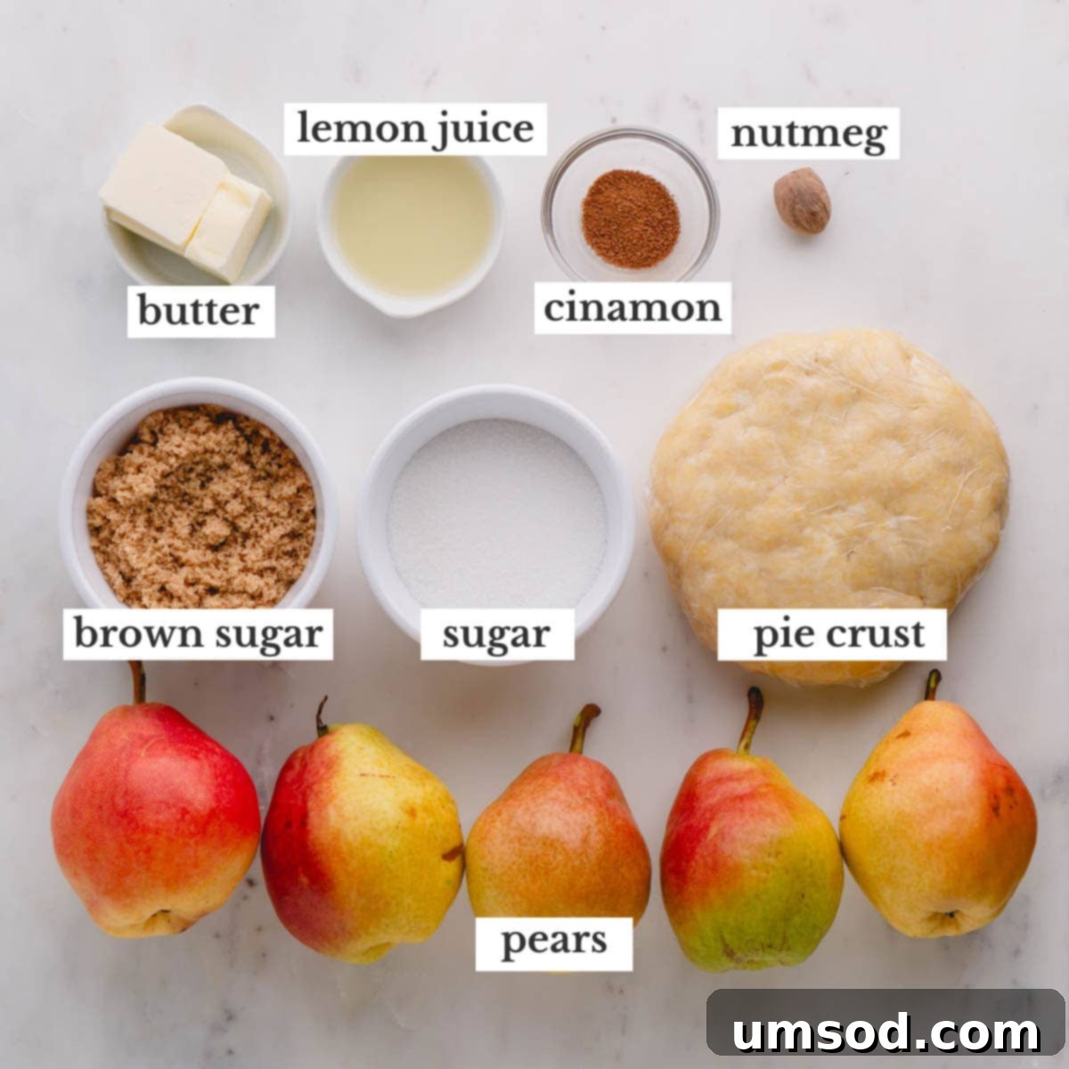 Golden Caramel Pear Tart 5 Ingredients laid out on a table to make pear tarte tatin, including pears, butter, sugars, and spices.