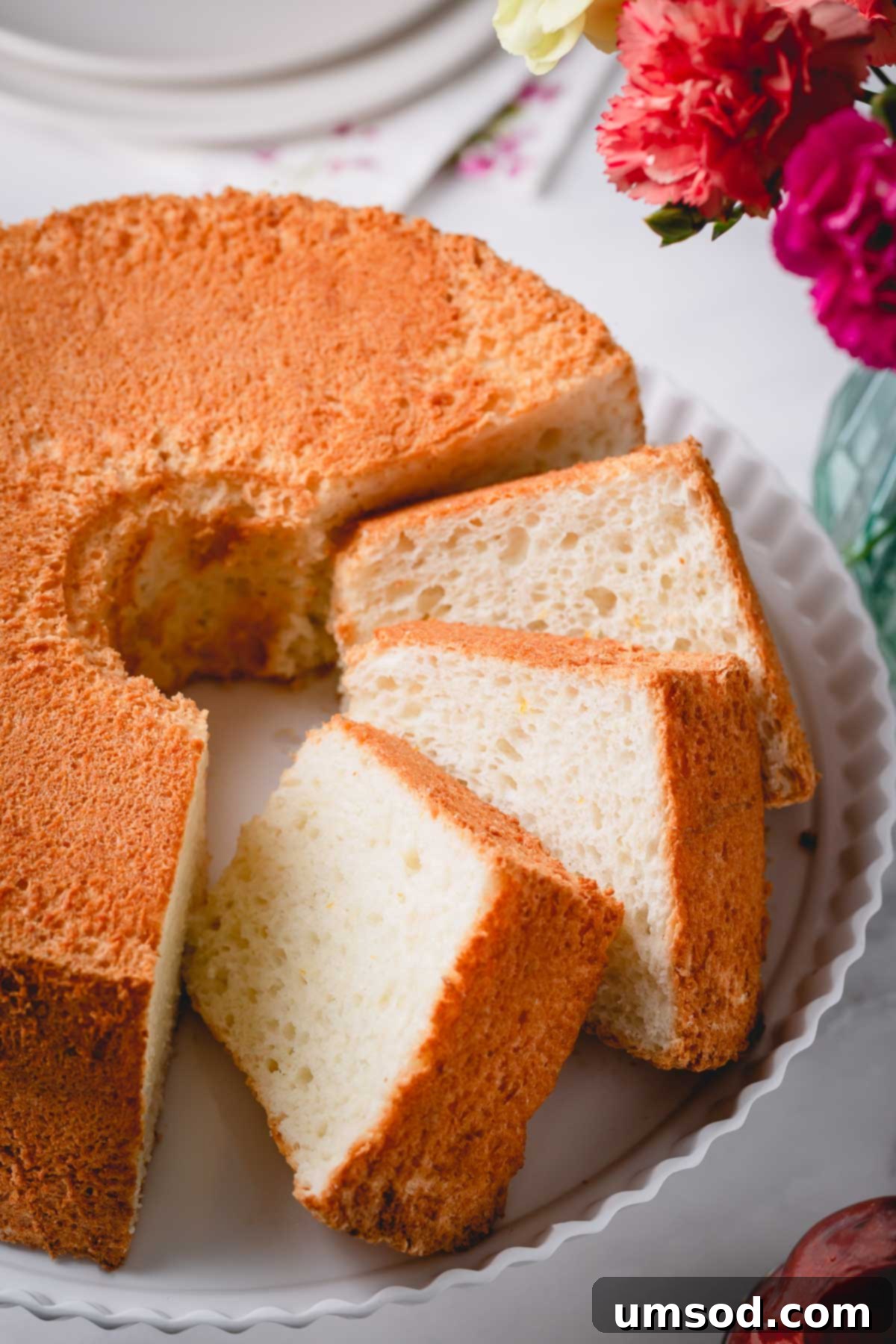 Cloud Nine Angel Food Cake 7 A beautifully sliced angel food cake resting on a cake platter, ready to be served.