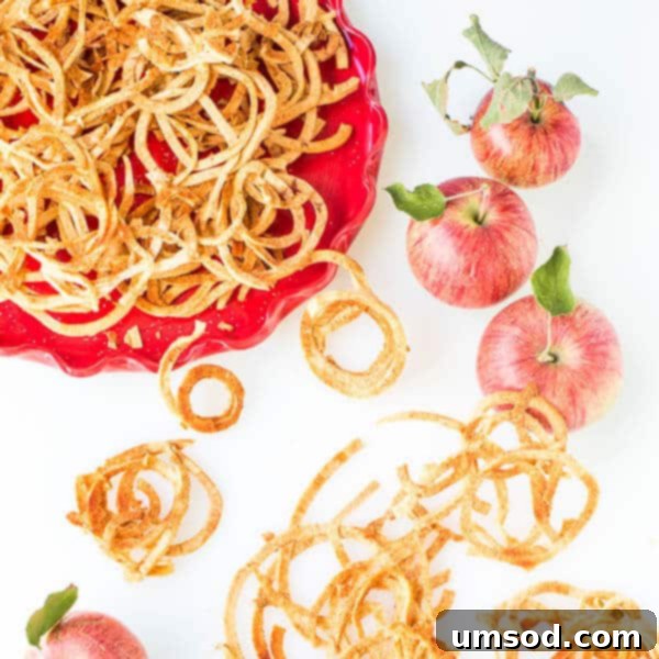 Platter of golden baked apple strings, showcasing their crispy texture.