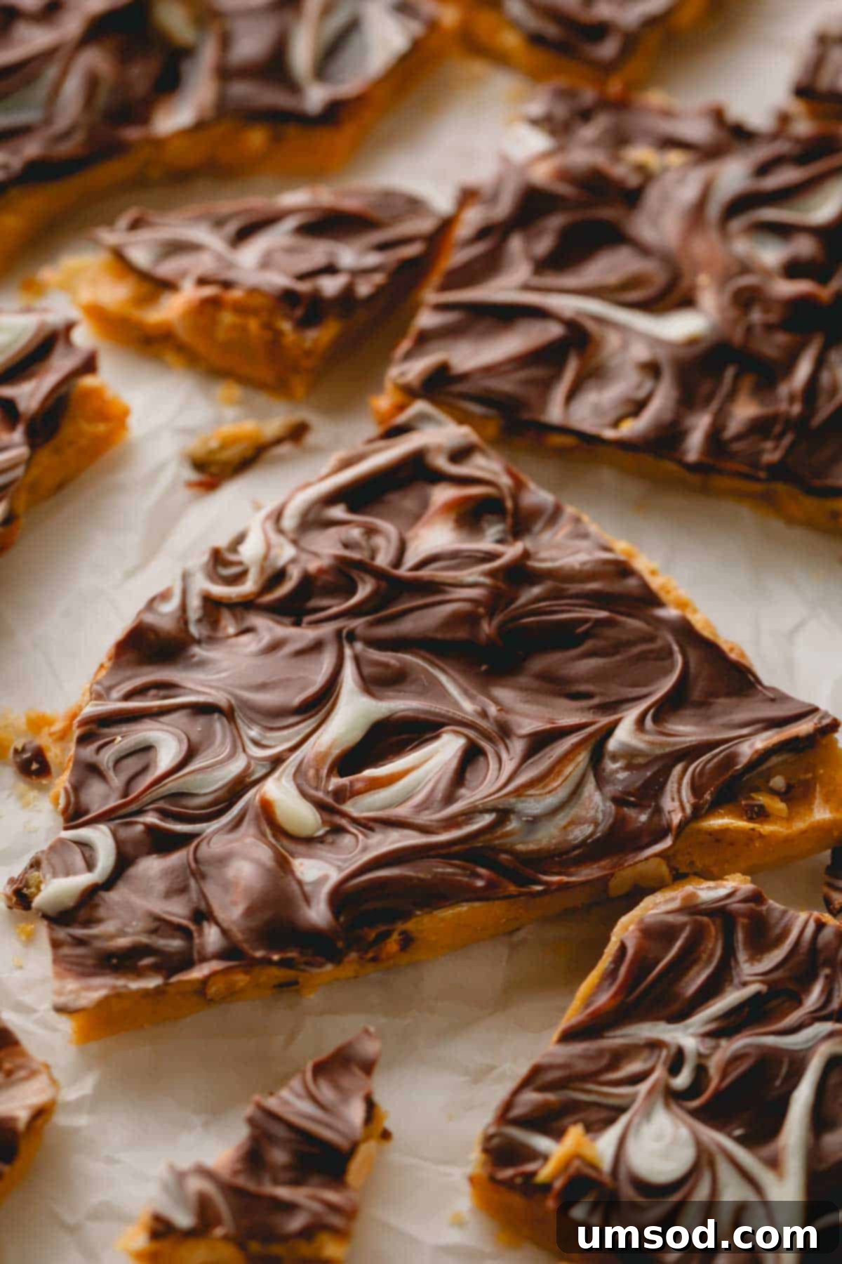 Irresistible pieces of homemade chocolate peanut brittle, showing its light and crunchy texture and a perfect chocolate swirl.