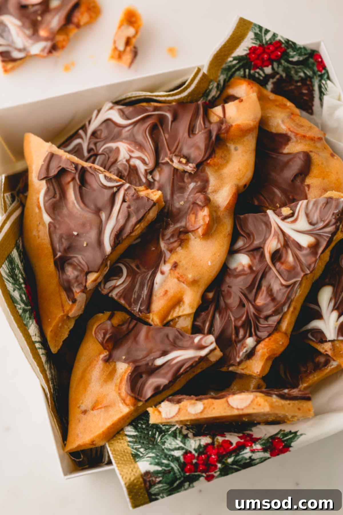 A charming gift box filled with individual pieces of chocolate peanut brittle, perfect for sharing.