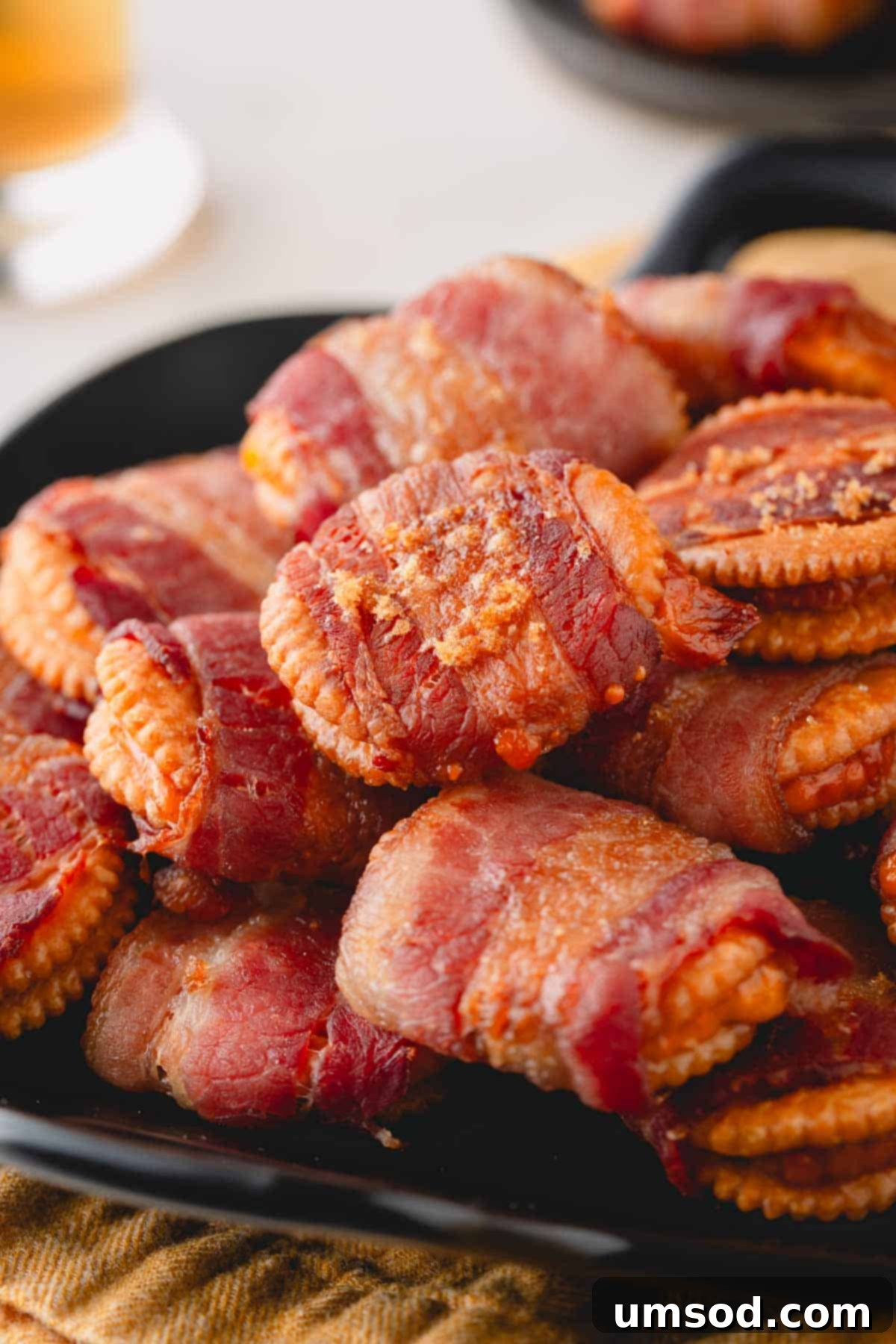 Smoky Bacon Cheese Bites 9 A close-up of a plate piled high with golden brown cheesy bacon crackers, sprinkled with brown sugar, ready to serve.