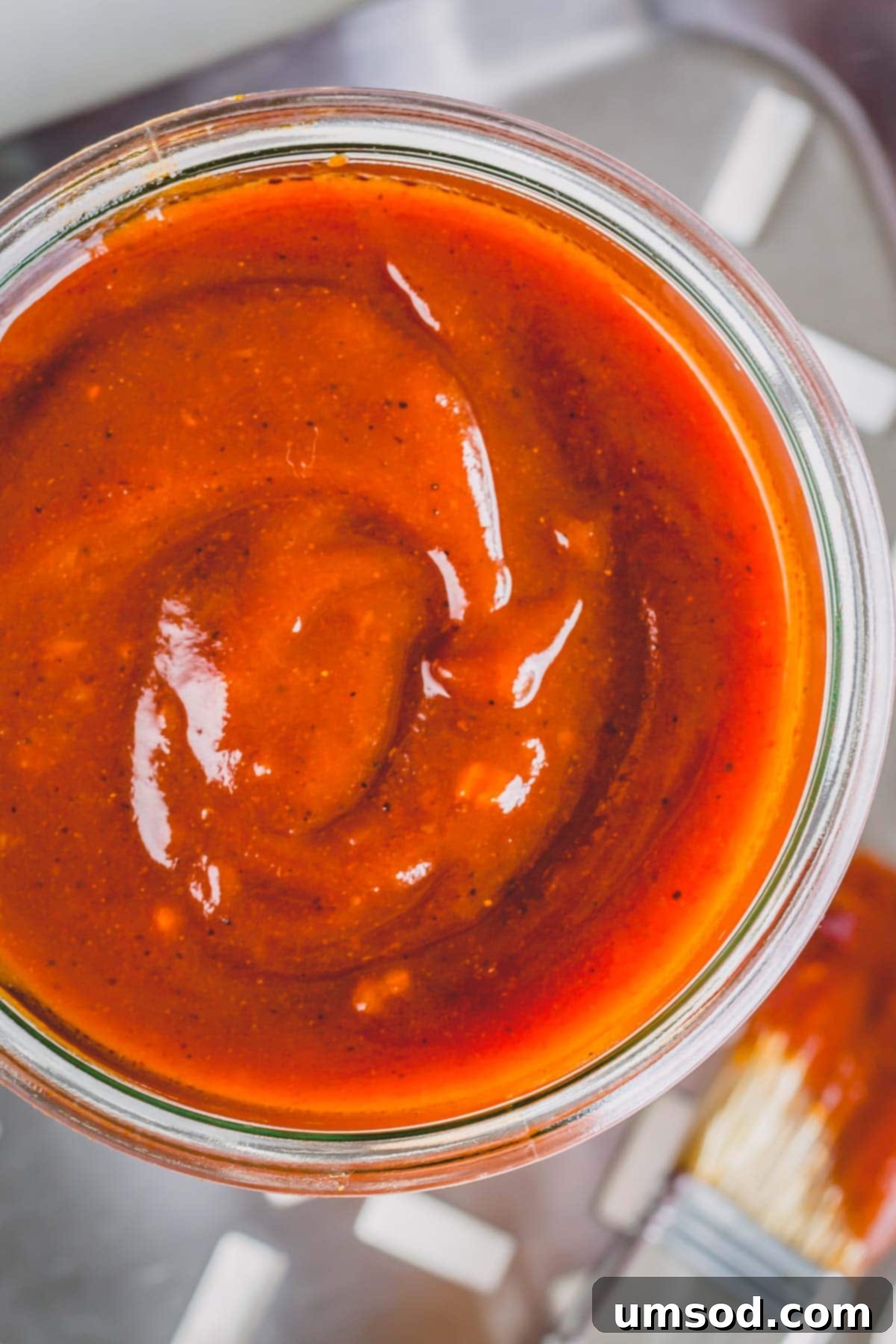 Easy Homemade BBQ Sauce Recipe 3 A close-up shot of a jar filled with rich, glossy homemade BBQ sauce, viewed from above, highlighting its inviting texture.