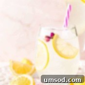 Pitcher of rose lemonade with garnishes ready for serving.