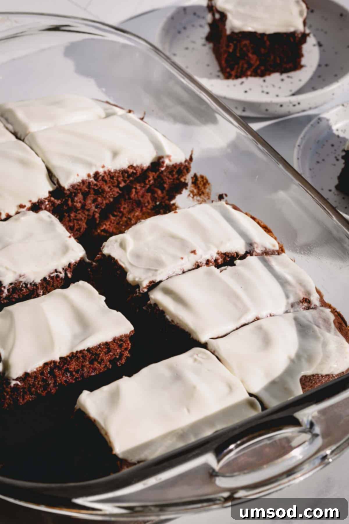 A beautiful 3-ingredient chocolate cherry cake generously covered with a soft, creamy cream cheese frosting, ready to be sliced and enjoyed.