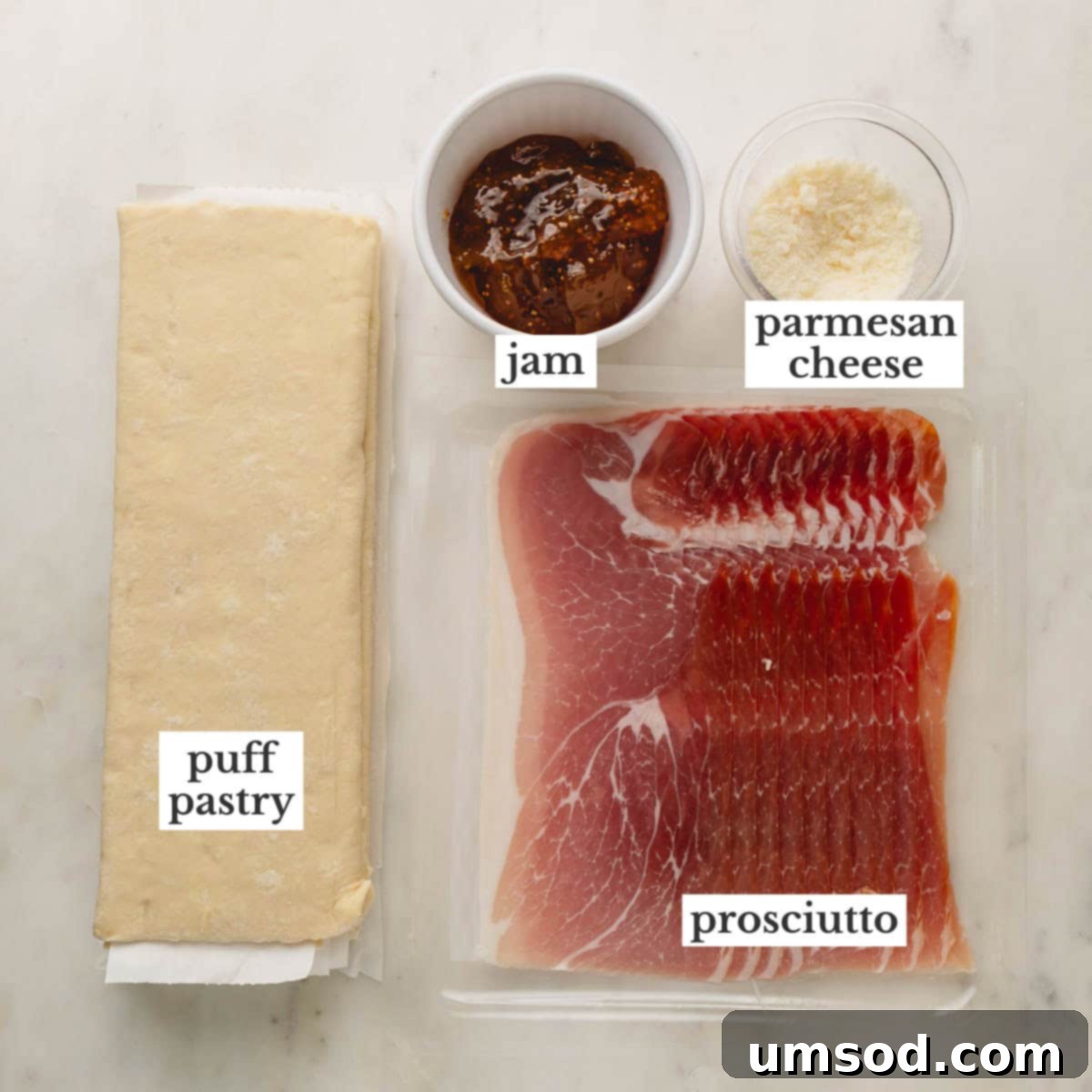 Puff pastry sheets, jam, parmesan cheese, and prosciutto laid out to make savory puff pastry twists.