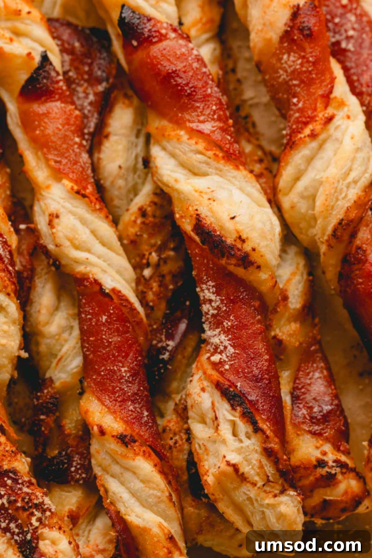 Puff pastry twists with apricot jam, prosciutto, and parmesan cheese, perfectly baked and ready to serve.