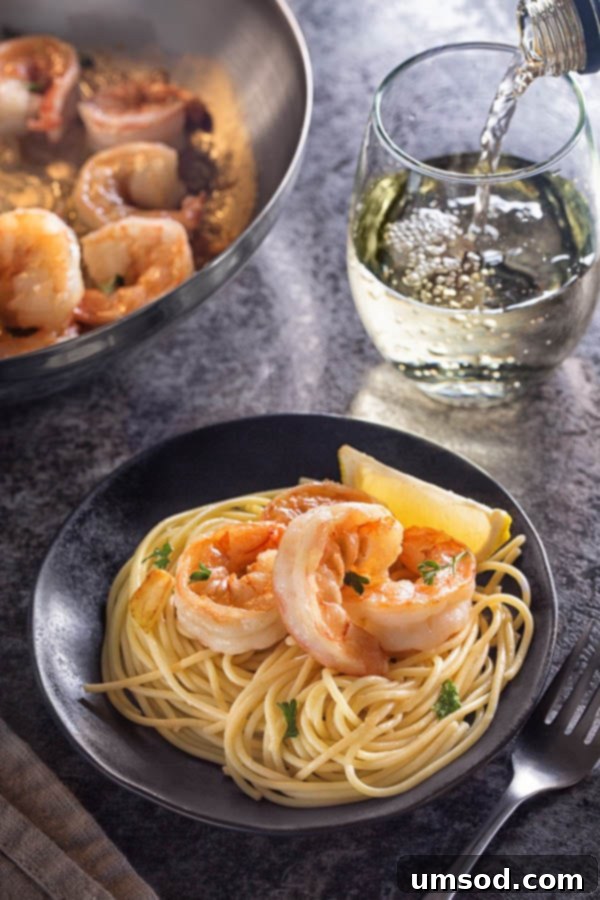 Garlic Butter Shrimp 5 Garlic butter shrimp served over angel hair pasta, garnished with fresh parsley, presented beautifully in a bowl.
