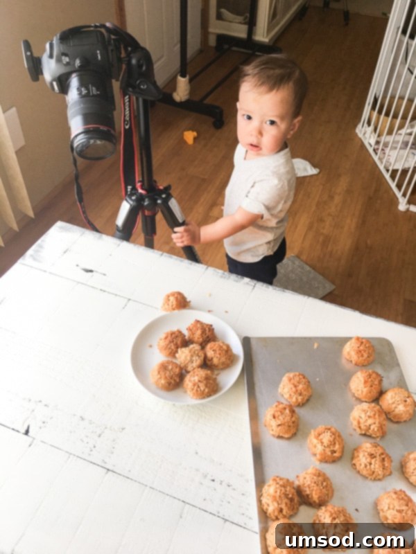 Toddler Grant holding a camera, pretending to take a picture of food, mimicking his mom.