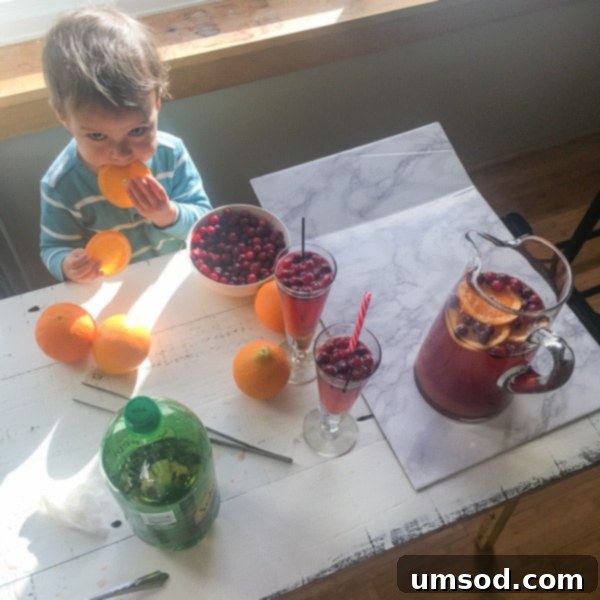 Toddler Grant enjoying a snack while sitting next to food photography setup.