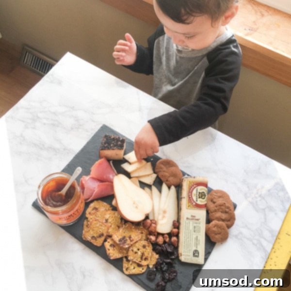 Close-up of Grant's hand reaching for a piece of food on a table during a photoshoot.