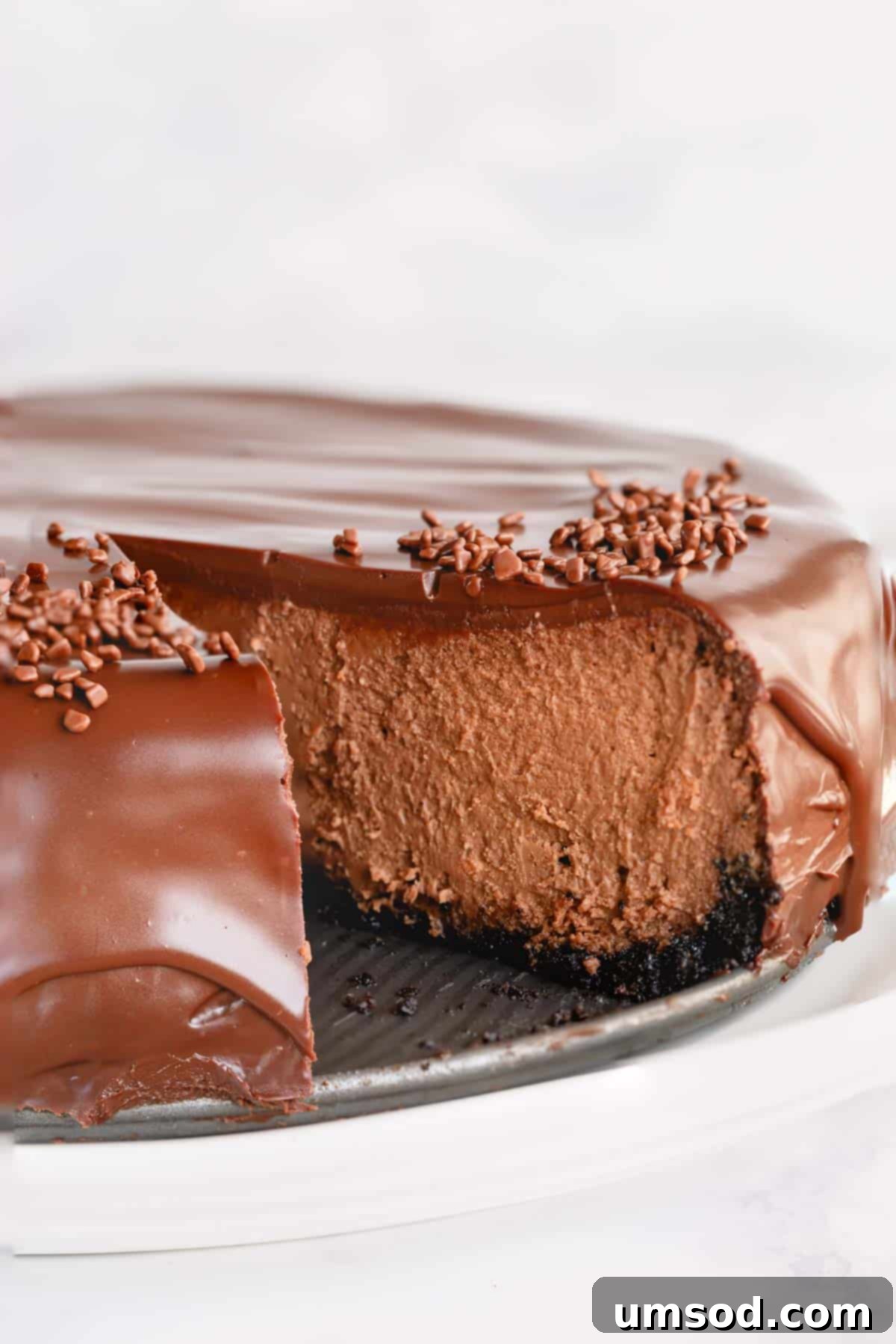 Supreme chocolate cheesecake with a slice missing. 