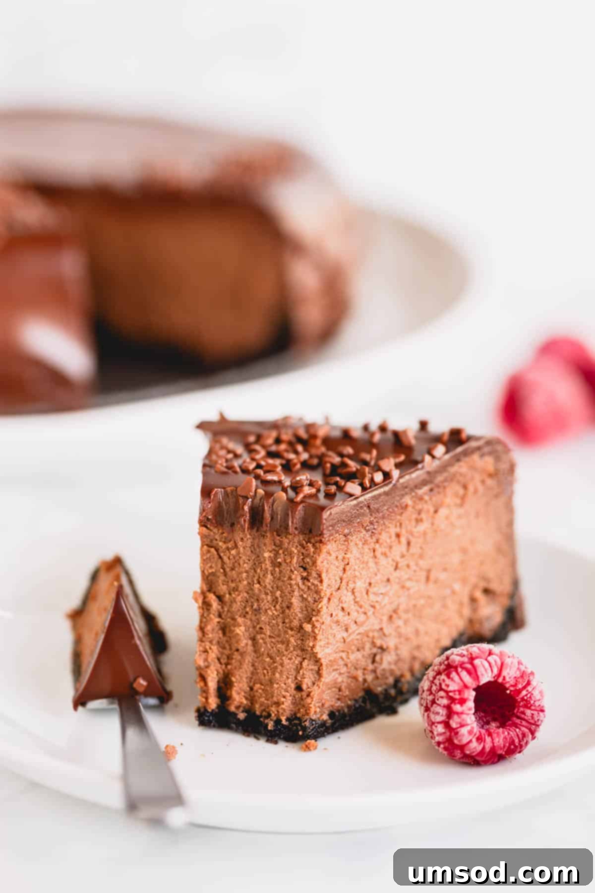 A slice of supreme chocolate cheesecake with a fork holding a bite. 