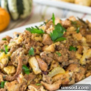 A platter of Instant Pot sausage stuffing garnished with fresh herbs.