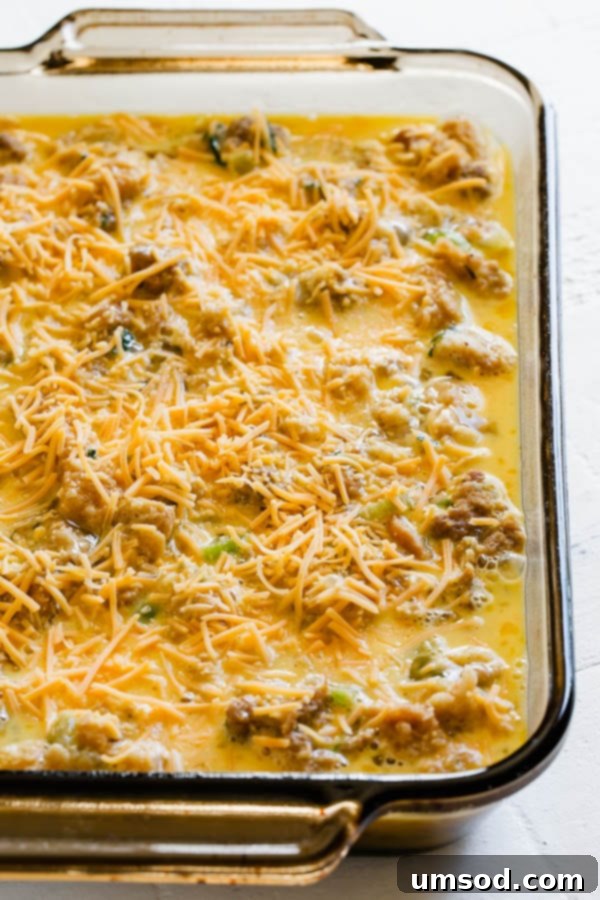 Stuffing Revival Breakfast Bake 5 An unbaked cheesy leftover stuffing breakfast casserole in a dish, ready for the oven, topped with grated cheese.