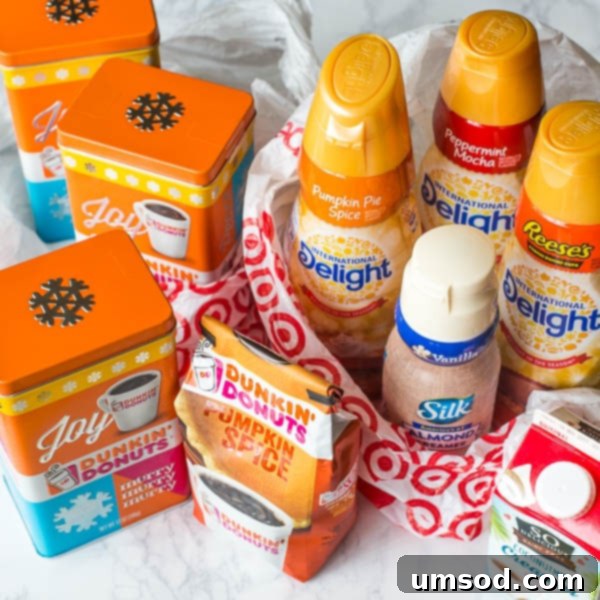 Sweet Crust Coffee 4 A collection of International Delight coffee creamers, including Peppermint Mocha, Pumpkin Pie Spice, and Reese's Peanut Butter Cup, arranged on a shelf.