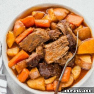 A classic pot roast, ready to be served, with a deep brown gravy and tender vegetables.