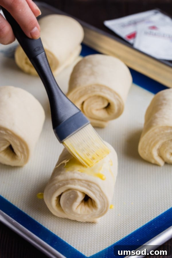 Flaky Chocolate Indulgence 8 Pain au chocolat smeared with egg wash before baking for a golden finish.