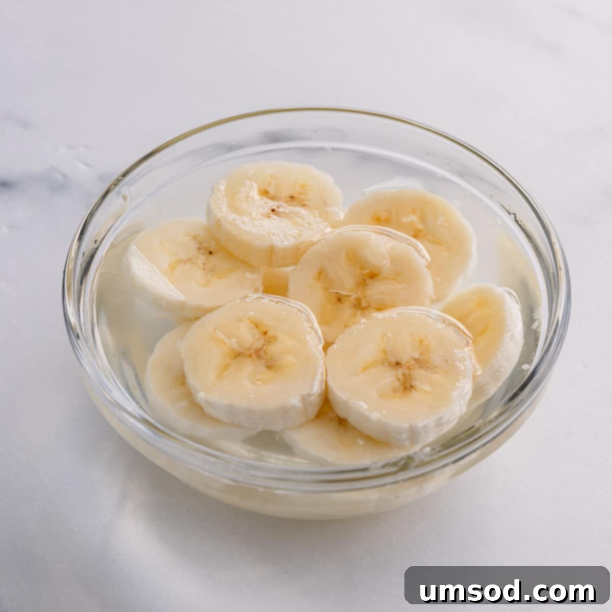 banana slices in a small bowl with lemon water.