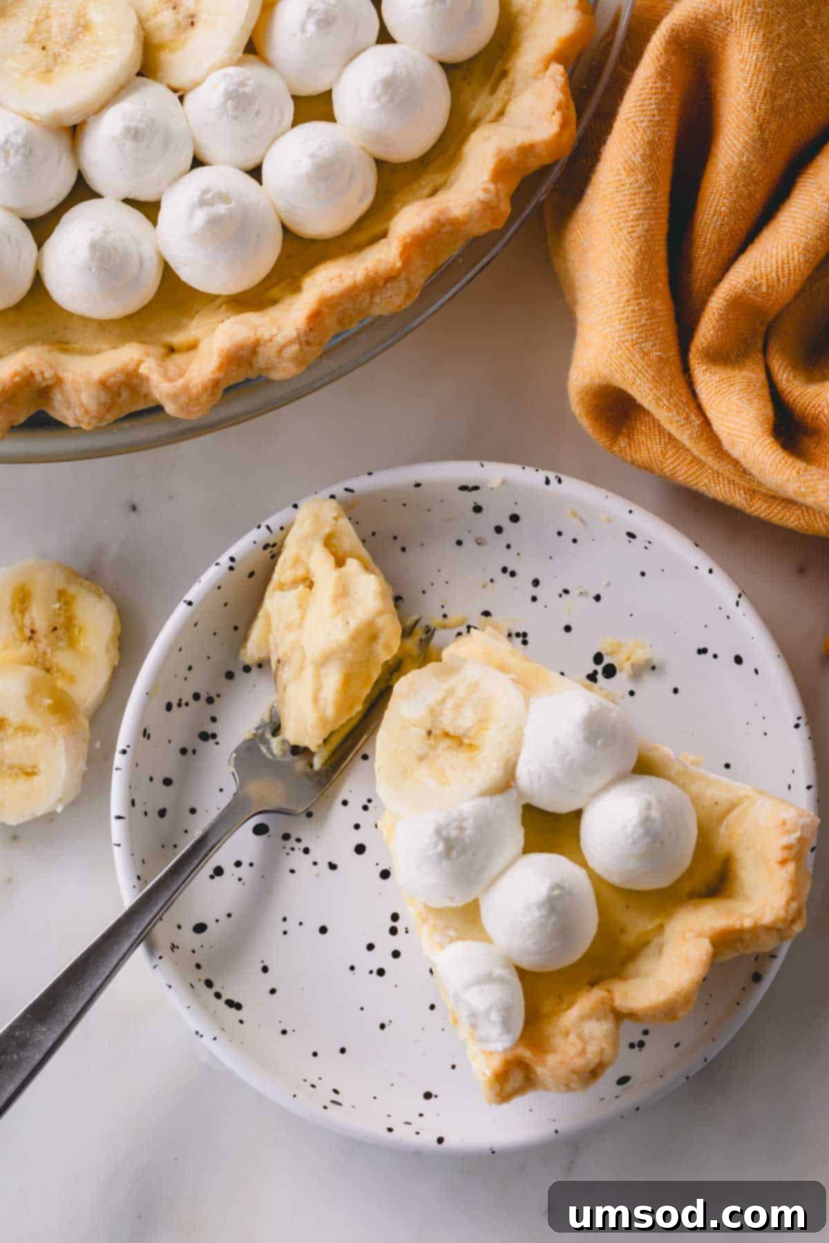 A slice of banana cream pie on a small plate.