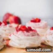 Luscious Strawberry Pavlova Bites 11 Mini strawberry pavlovas on a baking sheet, ready to be served.