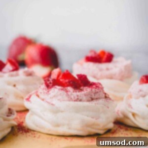 Luscious Strawberry Pavlova Bites 10 Mini strawberry pavlovas on a baking sheet, showcasing their delicate structure.