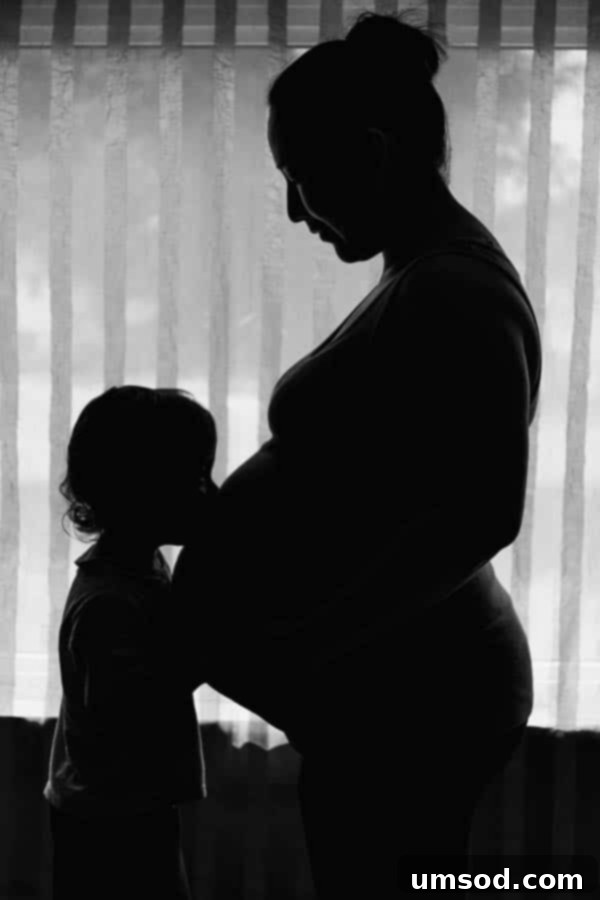 Excited parents anticipating the arrival of their second baby, showing a visibly pregnant belly.