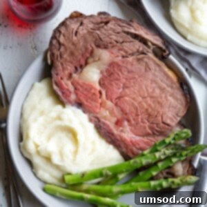 Ultimate Prime Rib Perfection 8 A plate of boneless prime rib roast, mashed potatoes, and asparagus.