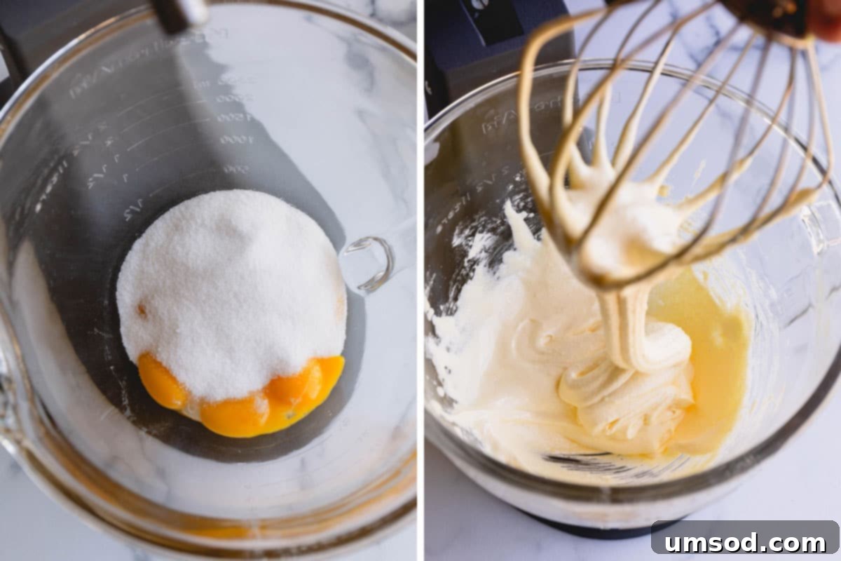Egg yolks and sugar being vigorously combined in a stand mixer to achieve a pale, voluminous mixture.