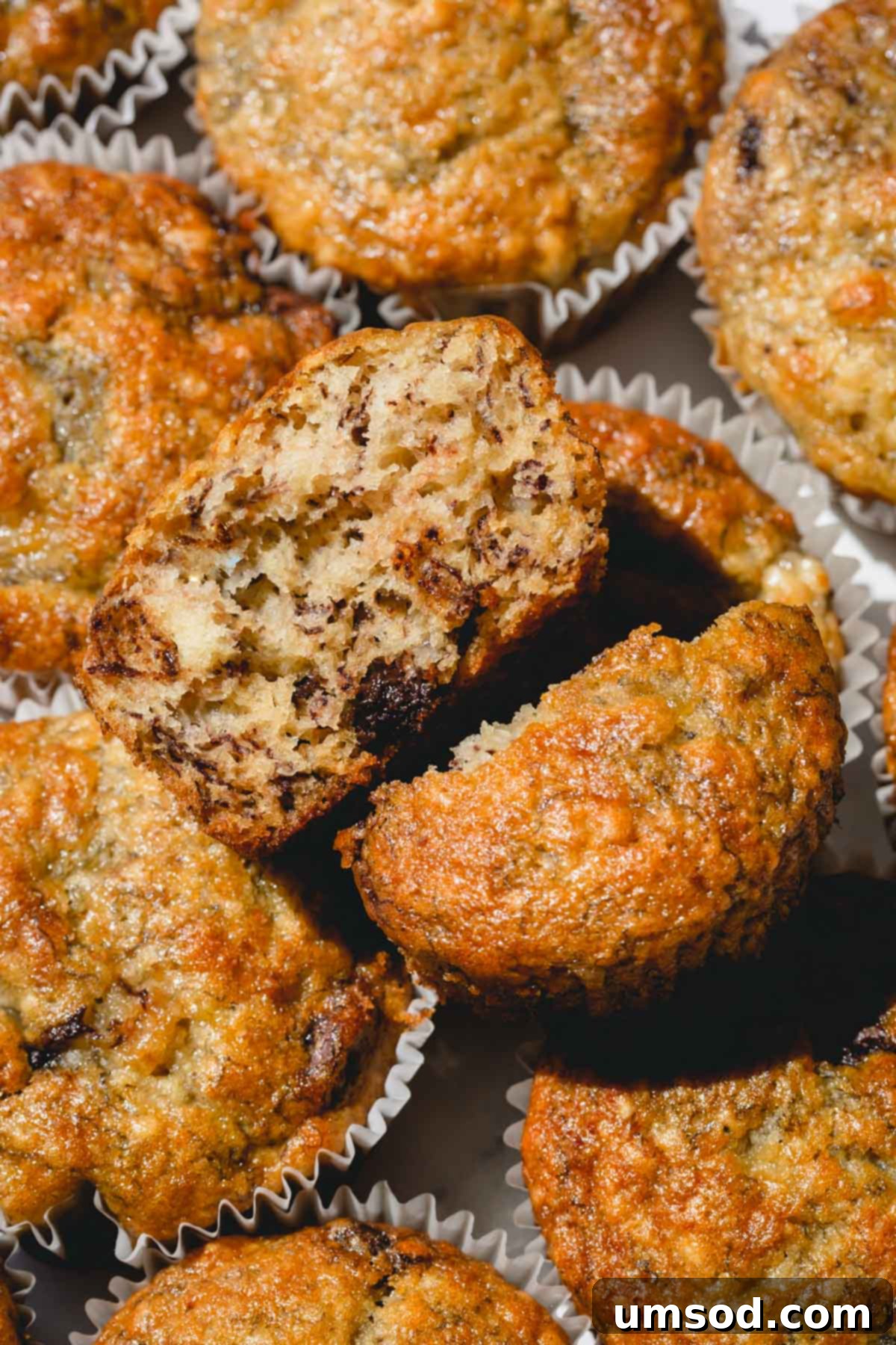 Effortless Banana Treats 10 A banana muffin with one cut in half, revealing the moist, tender interior.