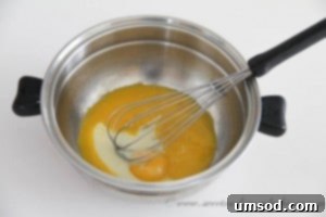 Tempering the egg yolk mixture by gradually adding hot cream, then returning it to the saucepan to thicken into a rich custard.