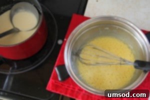 Straining the finished custard into a bowl with the remaining heavy cream, ensuring a perfectly smooth base for the ice cream.