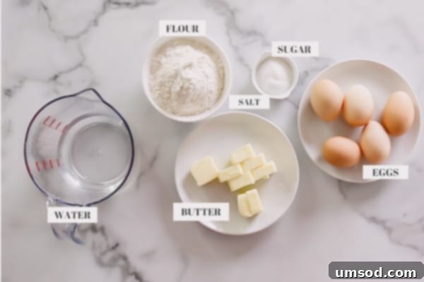 Eclair dough ingredients: water, butter, sugar, salt, flour, and eggs arranged on a surface.