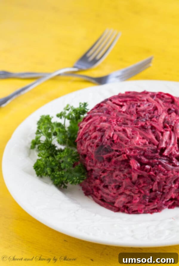 A beautifully plated serving of creamy roasted beet salad, garnished with fresh herbs, ready to be enjoyed.