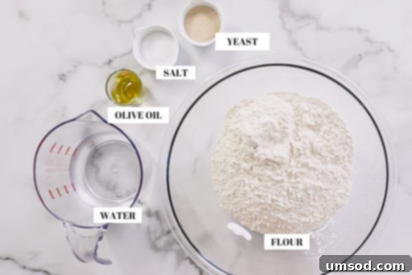 Effortless Homemade Pizza Dough 4 A selection of basic pizza dough ingredients laid out: all-purpose flour, water, a bottle of olive oil, a small pile of salt, and a packet of yeast.
