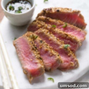 Seared and sliced ahi tuna with sesame crust on a platter.
