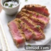 Seared and sliced ahi tuna with sesame crust on a platter.