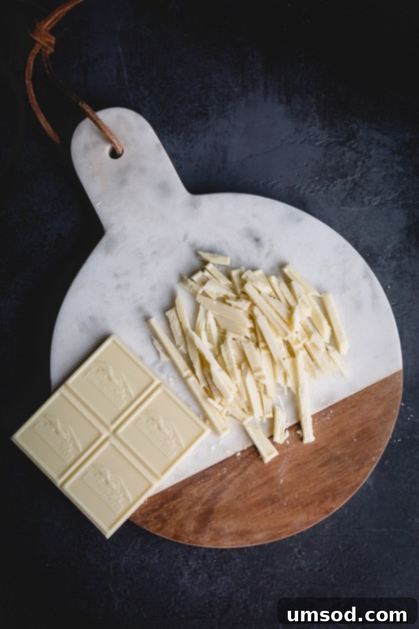 Finely chopped white chocolate pieces, meticulously prepared for making a smooth ganache filling.