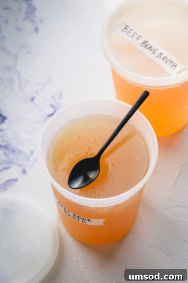 The Essential Guide to Beef Bone Broth 7 Cubes of frozen beef bone broth in an ice cube tray, and larger portions in freezer-safe containers.