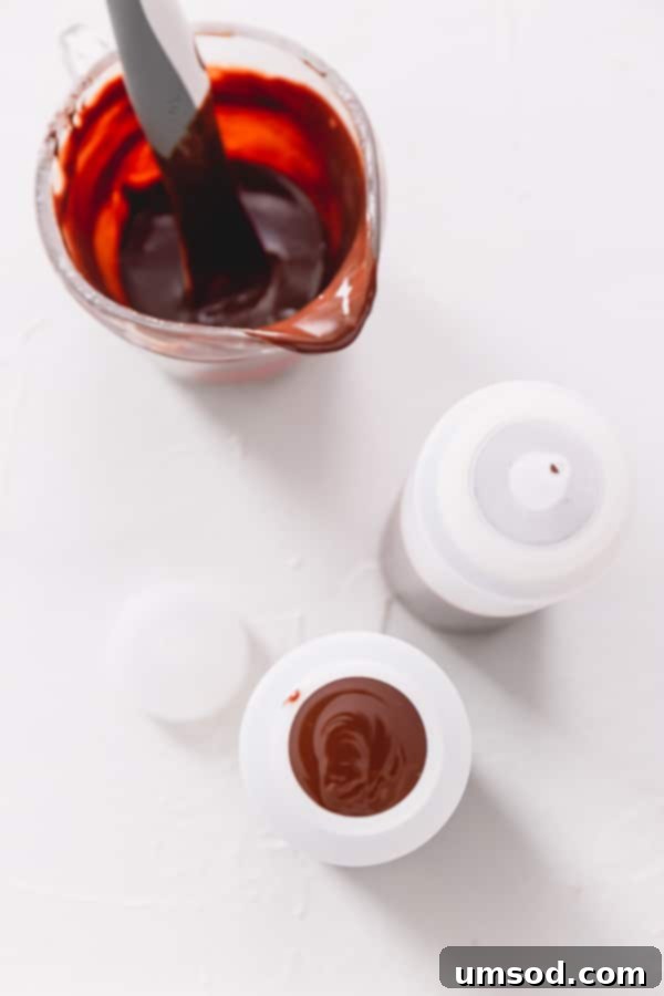 Chocolate Peanut Caramel Dream Cake 13 Ingredients for cake decoration: chocolate ganache in a measuring cup and two plastic squeeze bottles ready for filling.