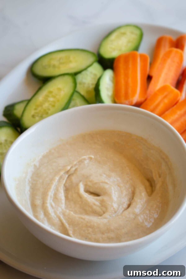 Dip into Delight: 5 Mouthwatering Sauce Recipes 12 A close-up of a variety of colorful dipping sauces in small bowls, arranged on a serving platter with fresh herbs.